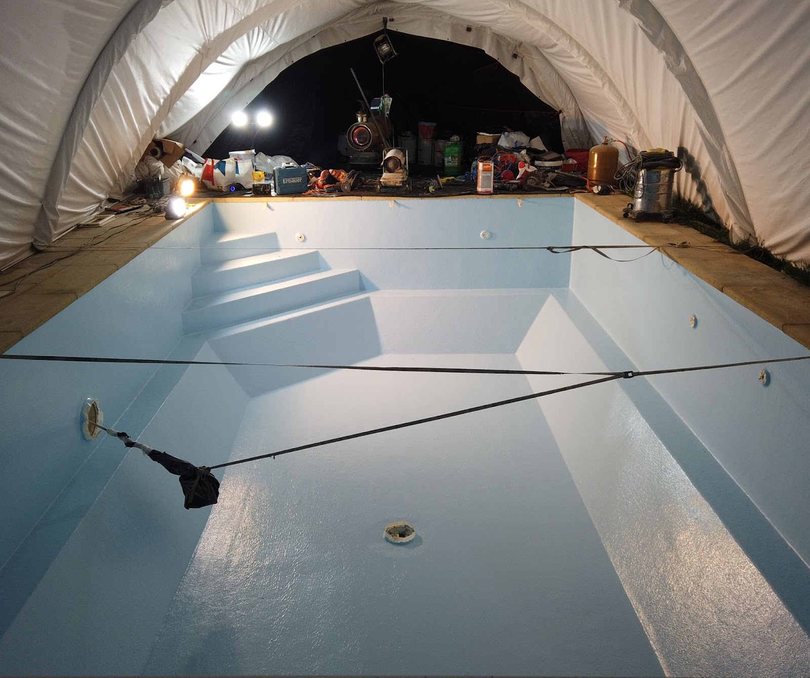 Piscine en béton rénovée par résine polyester. Gelcoat de finition bleu clair